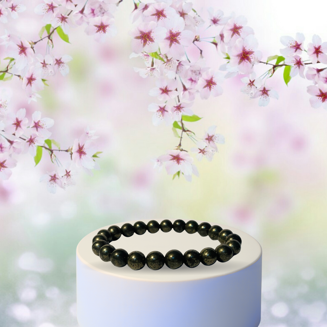 Oracryst Pyrite bracelet on a white stand with cherry blossom branches in the background for money